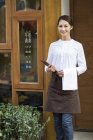 Chinesische Kellnerin steht in der Tür des Restaurants — Stockfoto