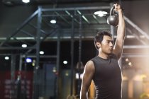 Chinesischer Mann trainiert mit Kettlebell in Crossfit-Fitnessstudio — Stockfoto