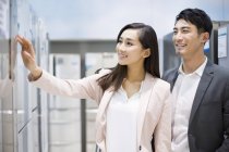 Chinese couple choosing refrigerator in electronics store — Stock Photo