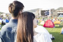 Женщина кладет голову на мужское плечо на музыкальном фестивале — стоковое фото