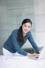 Empresária chinesa usando laptop no escritório — Fotografia de Stock