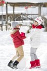 Chinesische Geschwister spielen mit Schneeball im Freien — Stockfoto