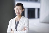 Chinese businesswoman standing with arms folded — Stock Photo