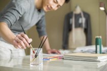 Chinesischer Modedesigner malt Skizze am Schreibtisch — Stockfoto