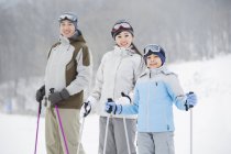 Chinese parents with son posing on snowy slope — Stock Photo