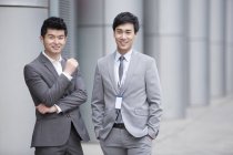 Uomini d'affari cinesi in piedi sulla strada e guardando in macchina fotografica — Foto stock