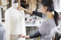 Créateur de mode chinois travaillant avec mannequin en studio — Photo de stock