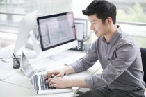 Китайський бізнесмен, використовуючи ноутбук в офісі — стокове фото