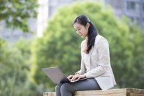 Empresária chinesa trabalhando com laptop na rua — Fotografia de Stock