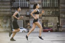Casal de corredores chineses correndo na rua — Fotografia de Stock