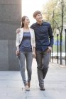 Chinesisches Paar läuft auf Bürgersteig in der Stadt und schaut weg — Stockfoto