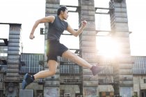 Chinese athlete running and jumping on street — Stock Photo