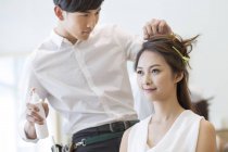 Chinese hairdresser working on customer hair — Stock Photo