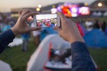 Male hands taking photos with smartphone at music festival — Stock Photo