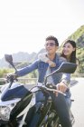 Китайская пара сидит на мотоцикле вместе — стоковое фото
