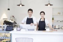 Casal chinês de pé no balcão do café — Fotografia de Stock