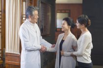 Medico cinese che stringe la mano ai pazienti nella sala d'ospedale — Foto stock
