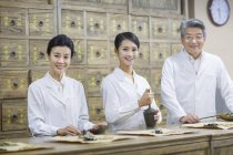 Китайские врачи позируют в традиционных аптеках — стоковое фото