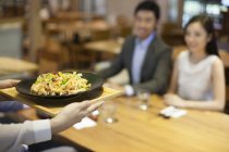 Kellnerin serviert Essen im Restaurant — Stockfoto