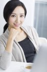 Portrait asian woman sitting at desk in office — Stock Photo
