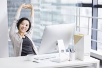 Cinese donna stretching e rilassante in ufficio — Foto stock