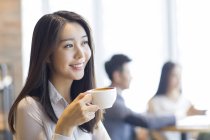 Chinese woman drinking coffee in cafe — Stock Photo