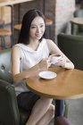 Giovane donna cinese in possesso di una tazza di caffè in caffè — Foto stock
