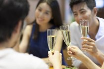 Chinese friends drinking champagne in restaurant — Stock Photo