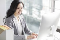 Китайський бізнес-леді за допомогою комп'ютера в офісі — стокове фото