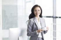 Donna d'affari cinese che prende una pausa caffè al lavoro — Foto stock