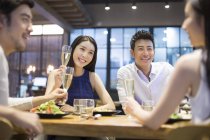 Chinese friends having dinner with champagne — Stock Photo