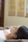 Mulher chinesa relaxante na mesa de massagem — Fotografia de Stock