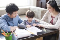 Китайський батьків, допомагаючи син з домашнє завдання — стокове фото