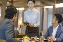 Chinesischer Geschäftsmann bezahlt Rechnung mit Kreditkarte im Restaurant — Stockfoto