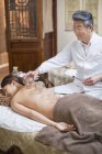 Thérapeute chinois effectuant un traitement de ventouses sur femme — Photo de stock