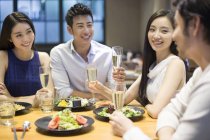 Chinese friends drinking champagne at dinner — Stock Photo