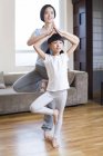 Chinesische Mutter und Tochter praktizieren Yoga im Wohnzimmer — Stockfoto