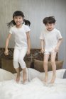 Китайські діти стрибають на ліжку — стокове фото