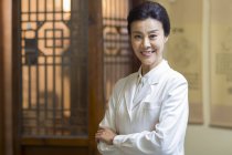 Retrato de médico chinês feminino com os braços dobrados — Fotografia de Stock