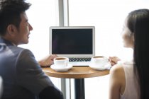 Pessoas de negócios chineses conversando com laptop no café — Fotografia de Stock