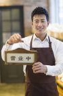 Chinese man holding open sign — Stock Photo
