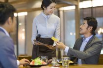 Chinese businessmen paying by credit card in restaurant — Stock Photo