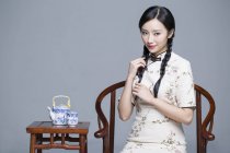 Chinese woman in traditional cheongsam with tea set — Stock Photo