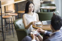 Китайський чоловік і жінка говорити в кафе з чашок кави — стокове фото