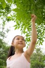 Junges chinesisches Mädchen hält ein Blatt im Park — Stockfoto