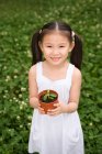 Junges chinesisches Mädchen hält eine Topfpflanze im Park — Stockfoto