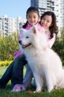 Mãe chinesa e filha com o cão da família — Fotografia de Stock