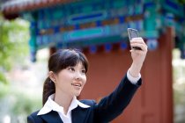 Китайка сідає на старий мобільний телефон. — стокове фото