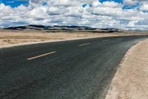 Road with mountains view and cloudy sky, Qinghai Province — Stock Photo