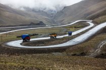 Lastwagen unterwegs in der tibetischen Berglandschaft, China — Stockfoto